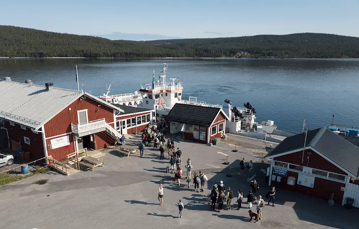 Bilden visar människor som köar vid färjeläget i Köpmanholmen.